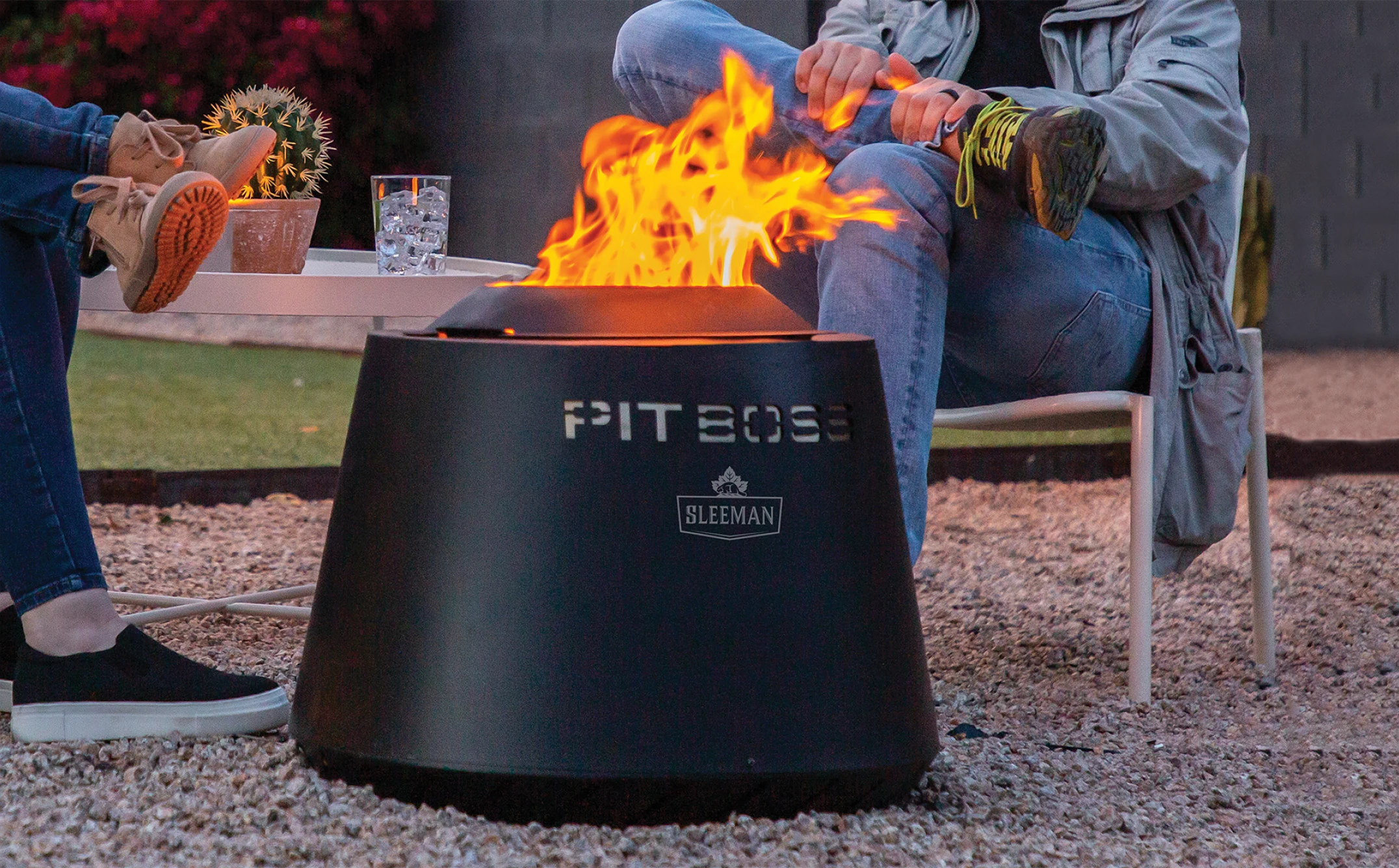 Image of 2 people sitting around a Pit Boss outdoor Fire Pit